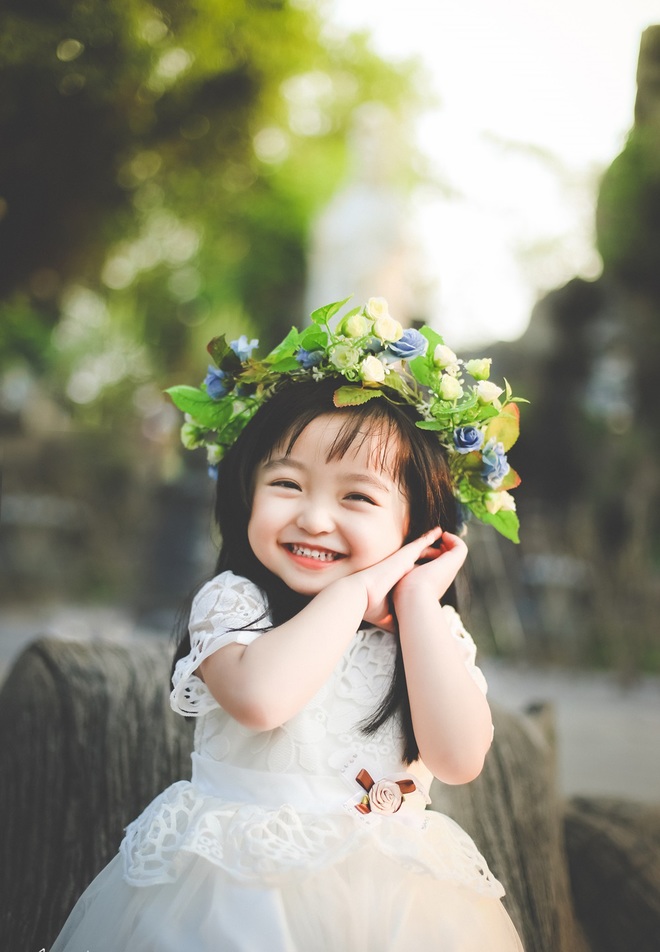 Hình em bé hàn quốc cười rất đáng yêu cùng vòng hoa trên đầu