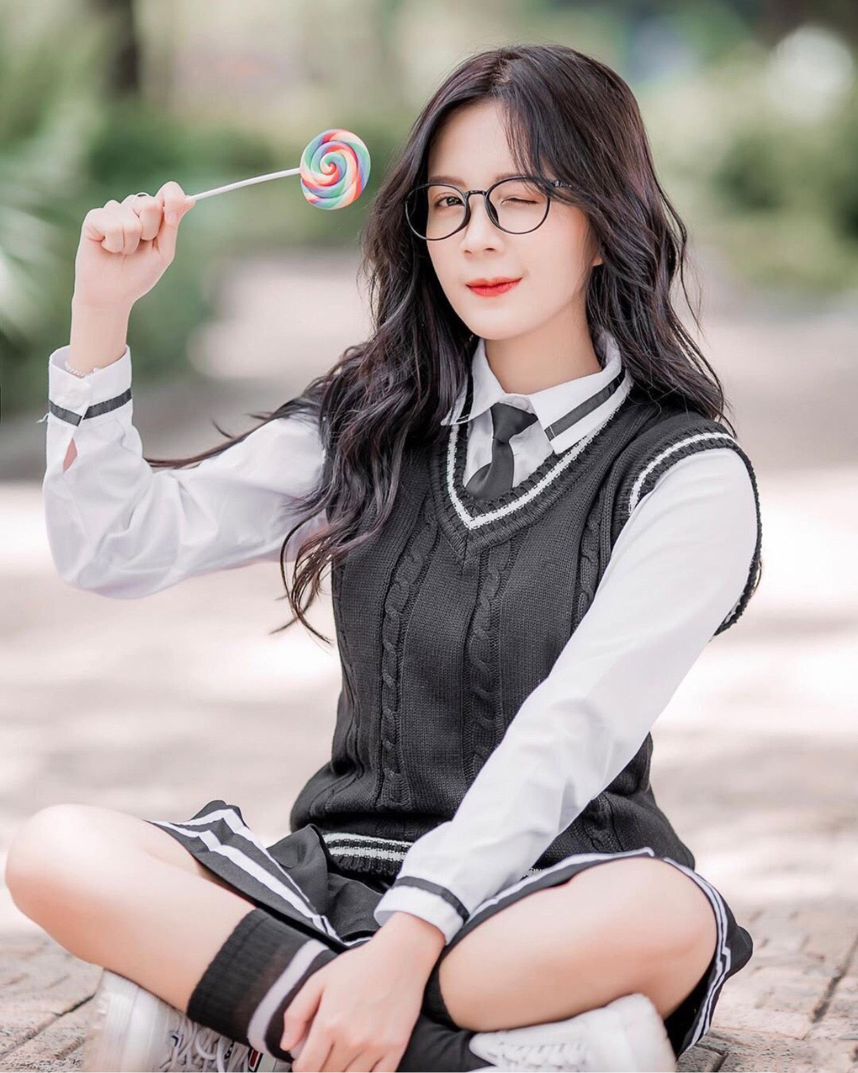Hình ảnh nữ sinh xinh đẹp đáng yêu đeo kính cầm chiếc kẹo mút màu cầu vồng
