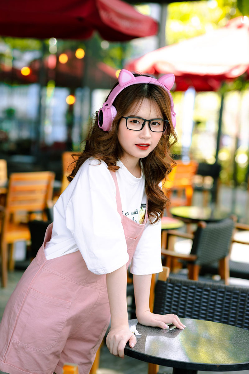 Hình ánh girl xinh đeo kính và tai nghe màu tai mèo cùng bộ đồ màu hồng cute