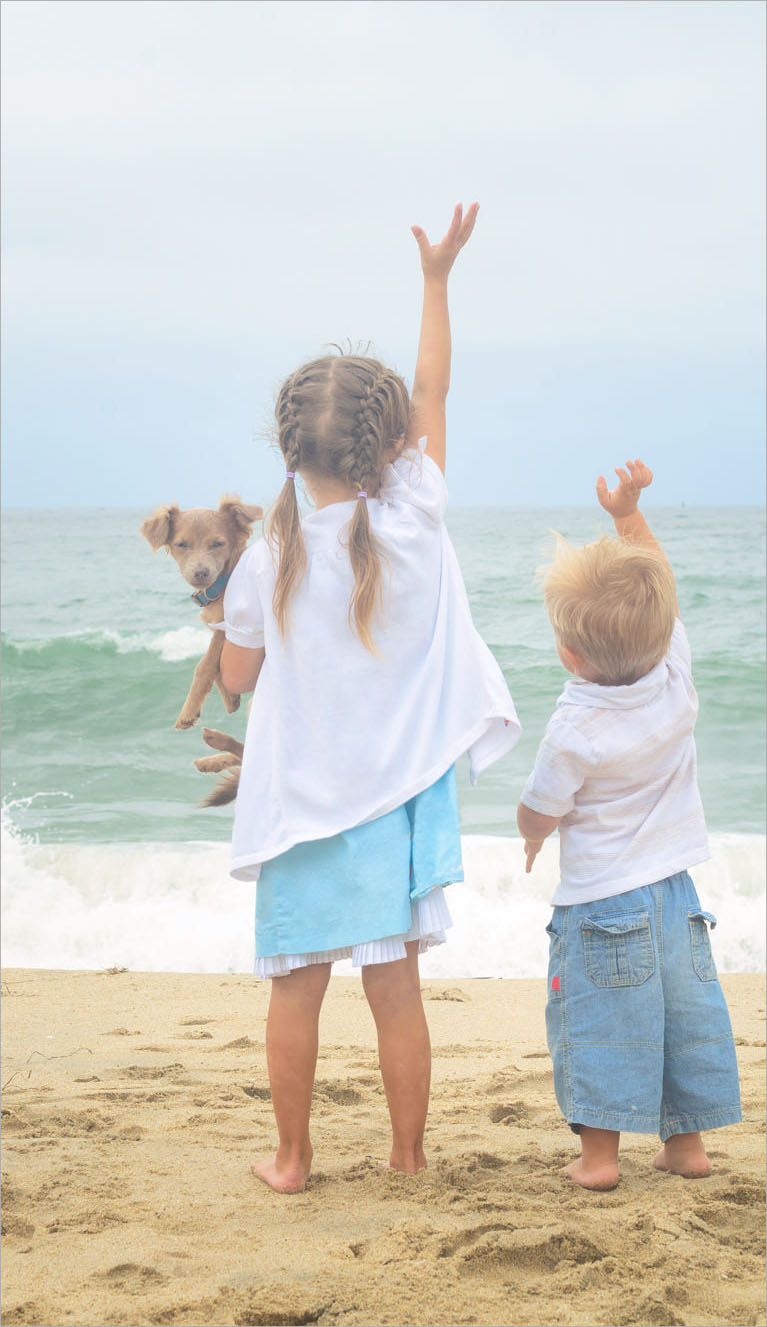 Hai đứa trẻ vẫy tay với biển