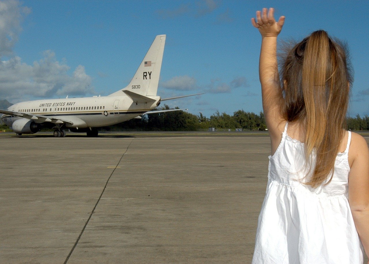 Cảnh cô bé vẫy tay với máy bay
