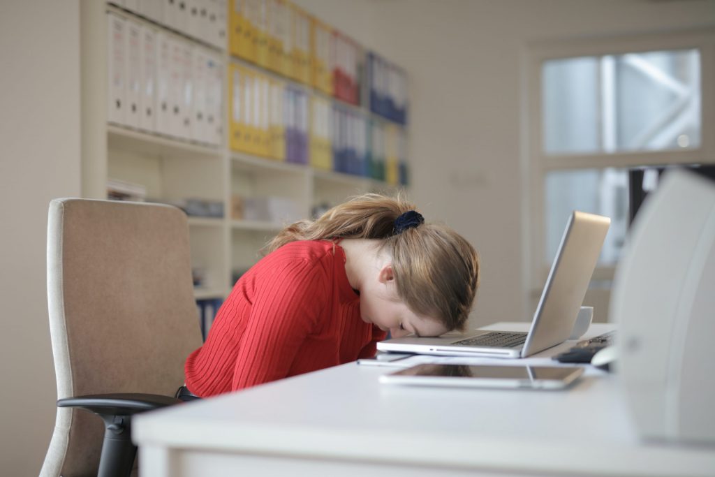 Người phụ nữ buồn ngủ gục đầu trên máy tình khi đang học