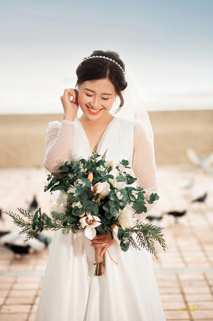 Khoảnh khắc cô dâu đang cười rất tươi cùng đóa hoa cưới màu trắng