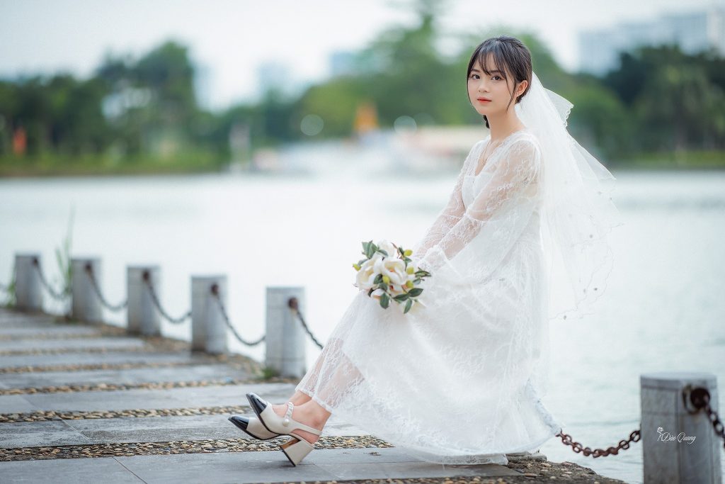 Cô dâu cầm đóa hoa trắng cùng bộ váy cưới giản dị rất xinh đẹp