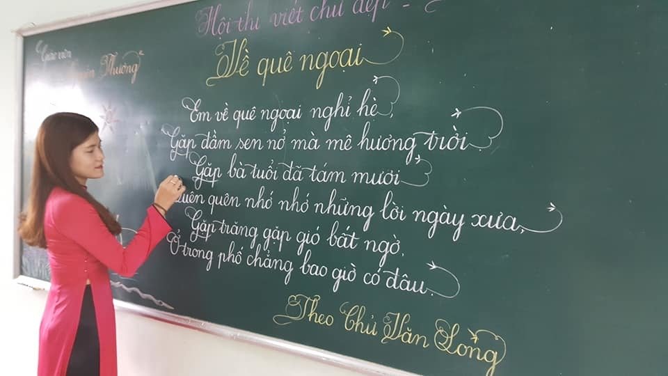 Hình cô giáo đang viết lên bảng bài thơ Về quê ngoại