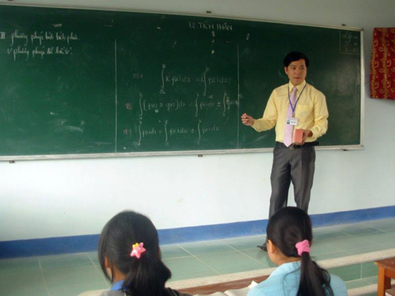 Thầy giáo đang giảng kiến thức toán trên bục giảng