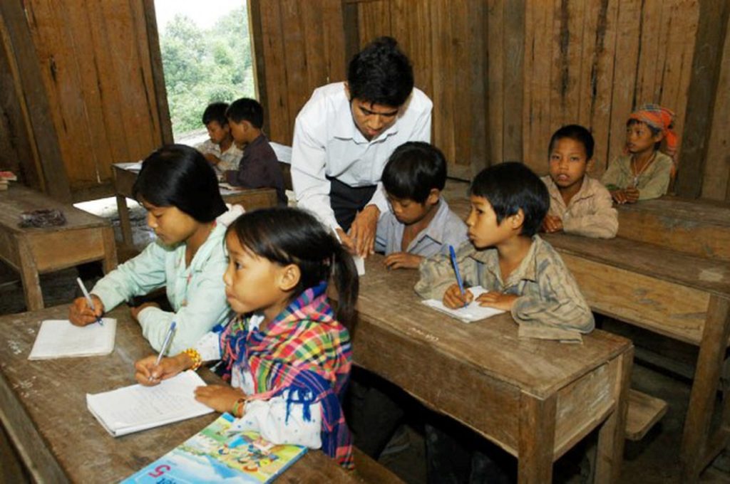 Thầy giáo đang giảng bài cho các em học sinh ở vùng cao nghèo khó