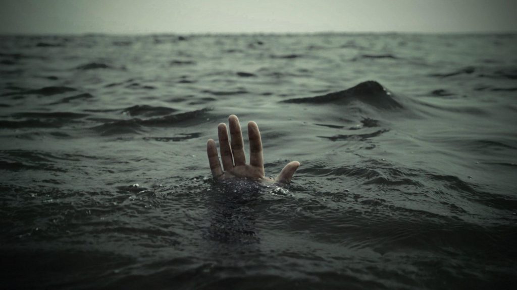 Ảnh bàn tay bất lực tuyệt vọng với lên khỏi mặt biển tĩnh lặng