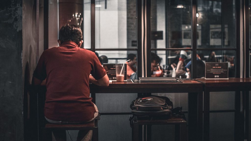 Ảnh chàng trai buồn tủi cô đơn ngồi học một mình trong quán cafe