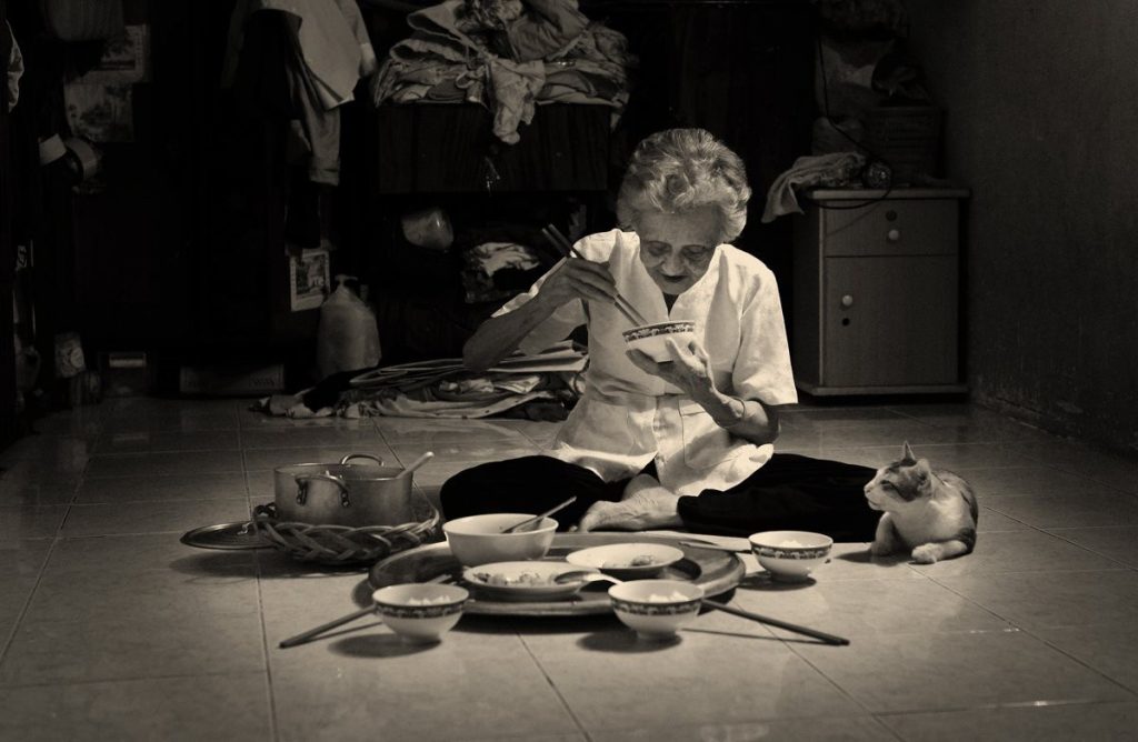 Hình ảnh người mẹ già vất vả cô đơn buồn tùi ngồi ăn cơm một mình