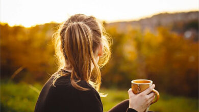 Cô gái chán nản, cầm ly cafe nhìn vào hư vô trước ánh chiều tà